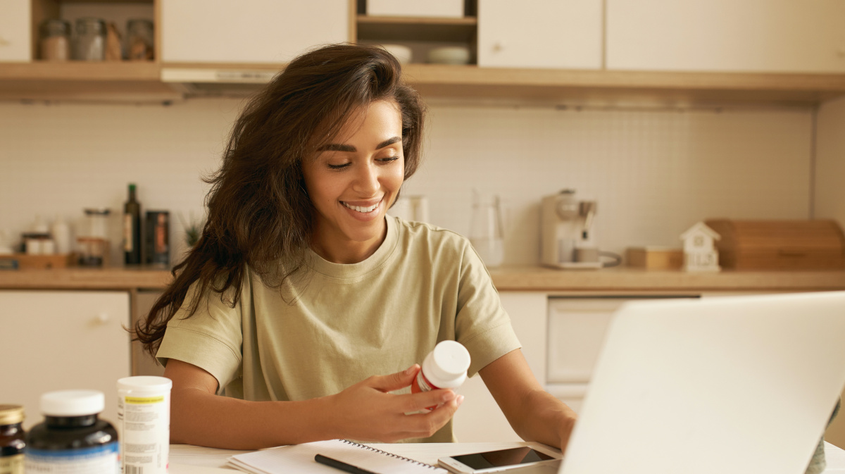 Jonge vrouw kiest een multivitaminesupplement