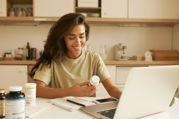 Mujer joven que elige su complejo multivitamínico