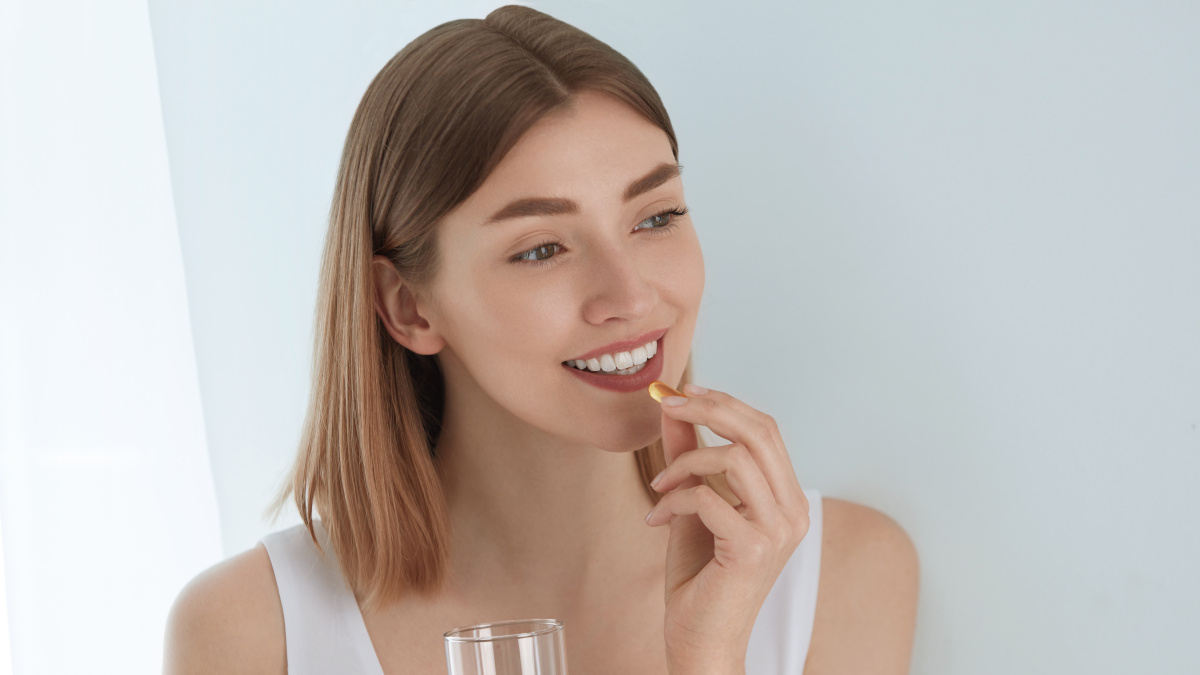 Mujer que toma un complemento alimenticio para la piel