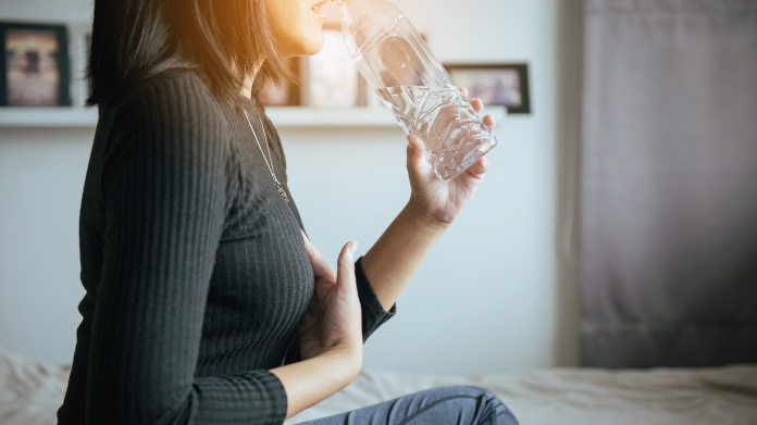 Seated woman suffering from acid reflux