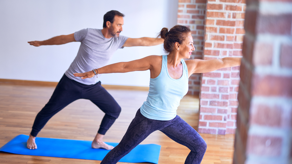 Una pareja a punto de hacer deporte sobre unas esterillas azules